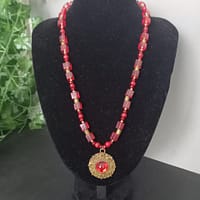 20250120_144553 Collier rouge avec pendentif soleil doré et cabochon rouge, perles de verre rouges et perles tibétaines dorées.