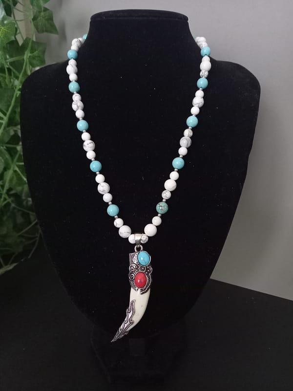 20250120_144907 Collier avec perles de howlite bleu et blanche, pendentif griffe décoré d’alliage argenté incrusté de pierres howlite bleu et rouge.