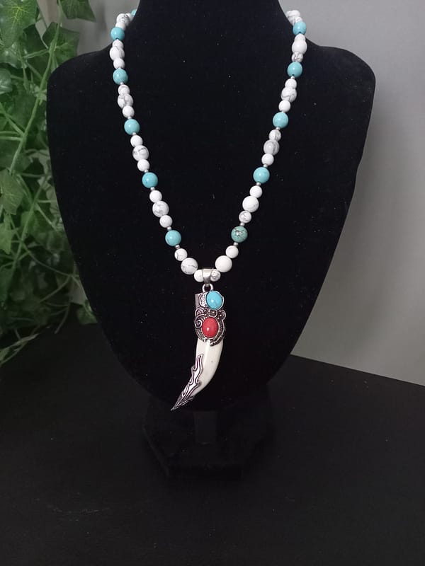 20250120_144913 Collier avec perles de howlite bleu et blanche, pendentif griffe décoré d’alliage argenté incrusté de pierres howlite bleu et rouge.