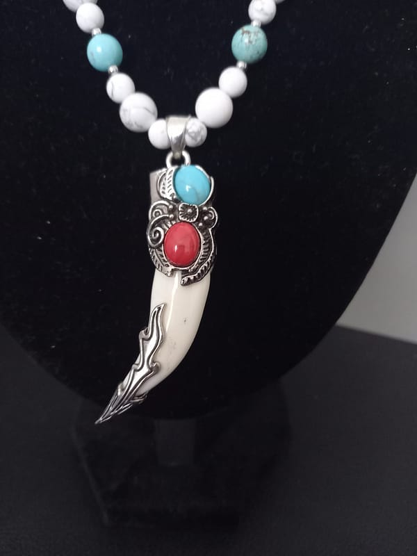 20250120_144919 Collier avec perles de howlite bleu et blanche, pendentif griffe décoré d’alliage argenté incrusté de pierres howlite bleu et rouge.