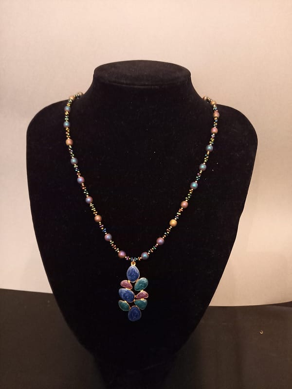 Parure élégante en perles électrolyse bleu-violet : collier avec pendentif assorti et bracelet.