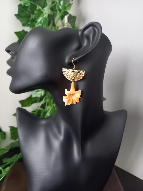 Boucles d’oreilles avec fleur de corail orange suspendue, demi-cercle doré martelé et libellule.