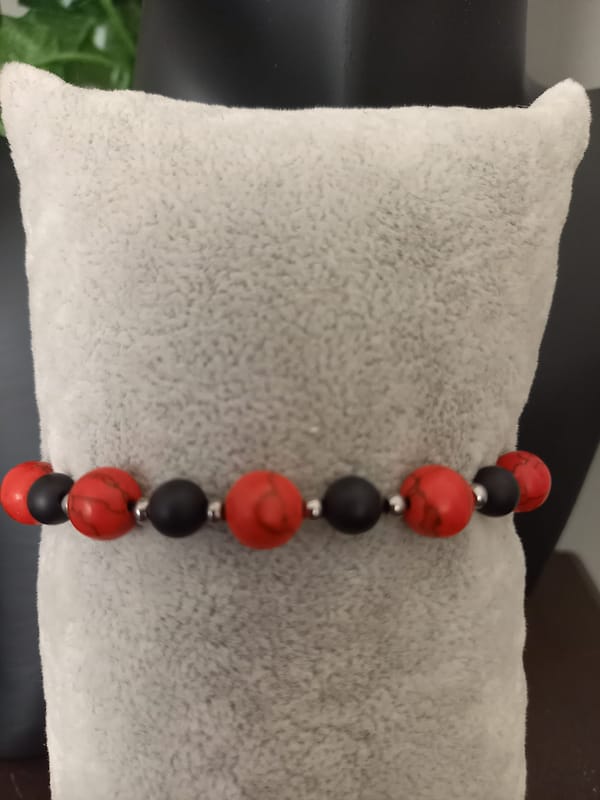 20250203_170132 Bracelet en perles opaques rouge marbré et noir, séparées par des perles en acier inoxydable