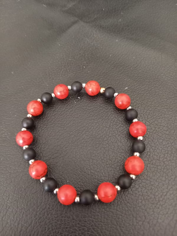20250203_170228 Bracelet en perles opaques rouge marbré et noir, séparées par des perles en acier inoxydable