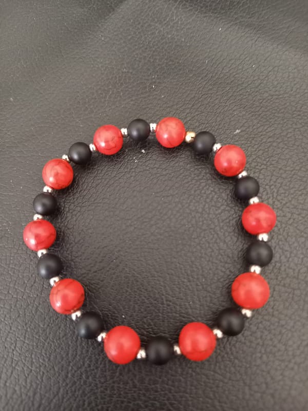 20250203_170239 Bracelet en perles opaques rouge marbré et noir, séparées par des perles en acier inoxydable