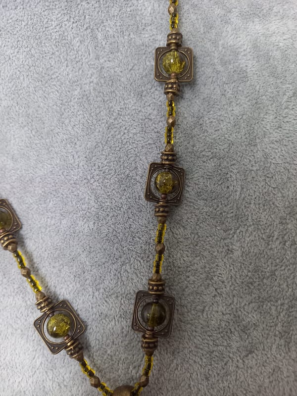 20250423_125748 Collier rétro en perles vert kaki et bronze tibétain, orné d’un pendentif en assorti.