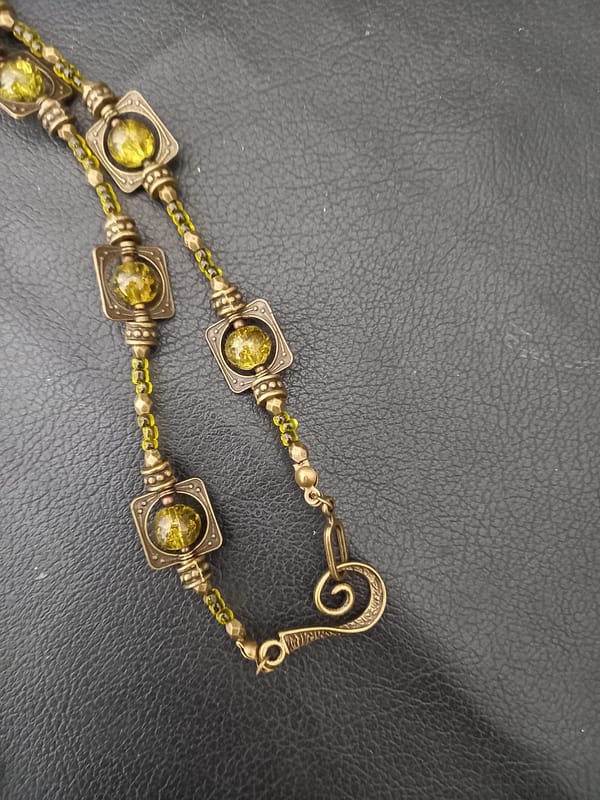 20250423_125818 Collier rétro en perles vert kaki et bronze tibétain, orné d’un pendentif en assorti.