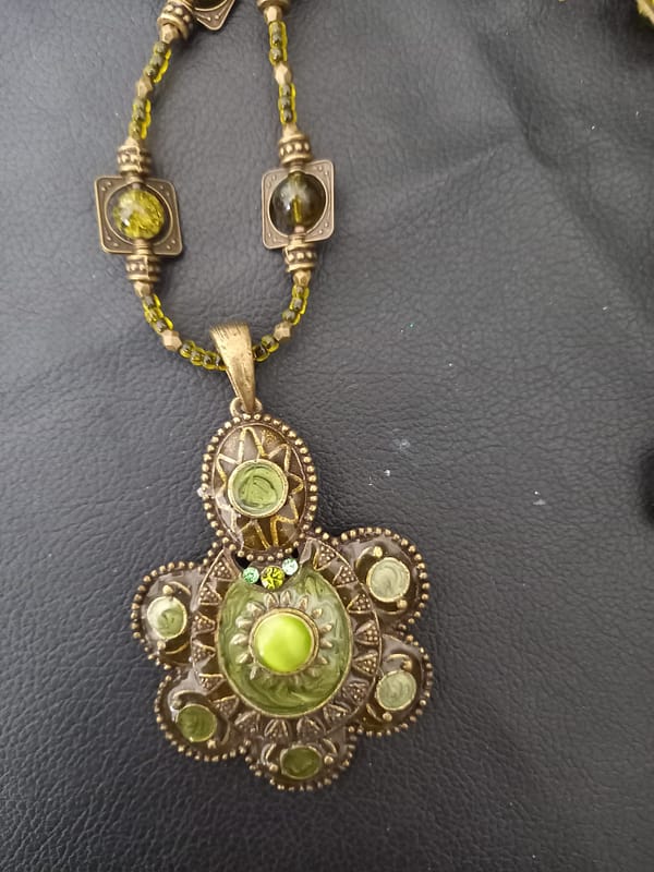 20250423_125822 Collier rétro en perles vert kaki et bronze tibétain, orné d’un pendentif en assorti.