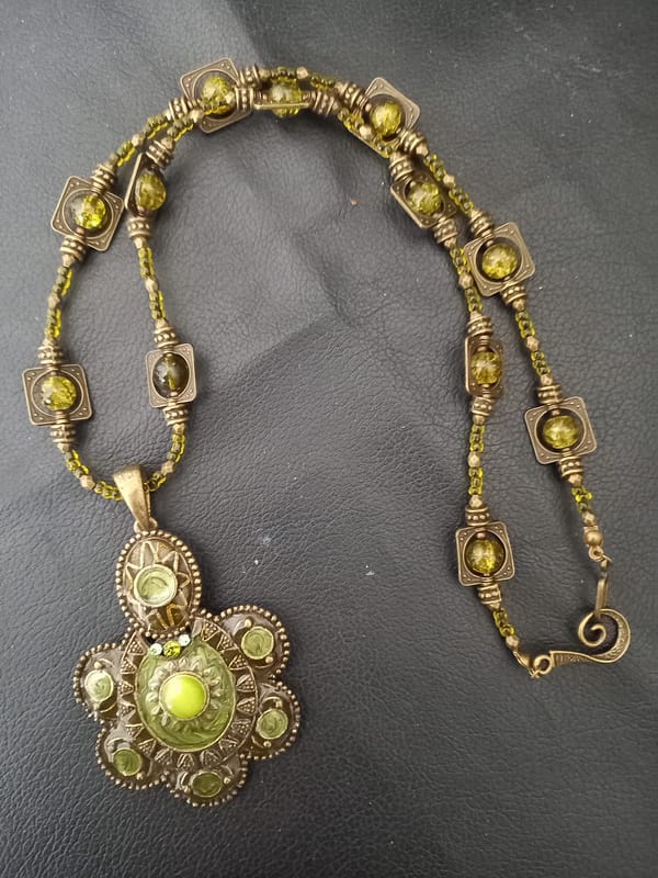 20250423_125830 Collier rétro en perles vert kaki et bronze tibétain, orné d’un pendentif en assorti.